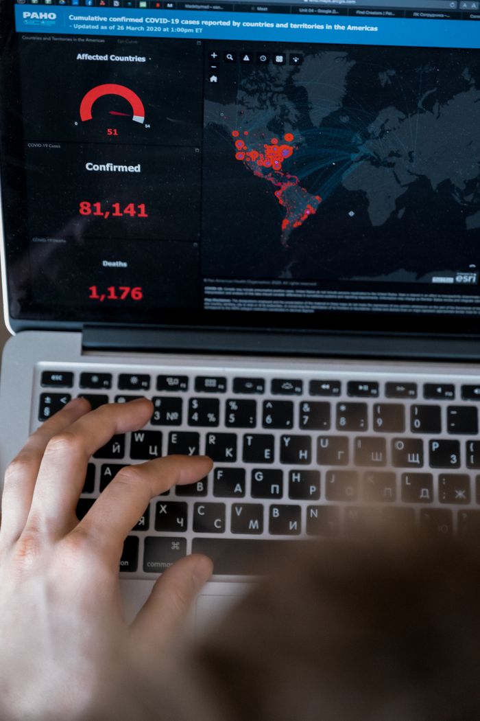 services-img Person using laptop to view COVID-19 data map and statistics.